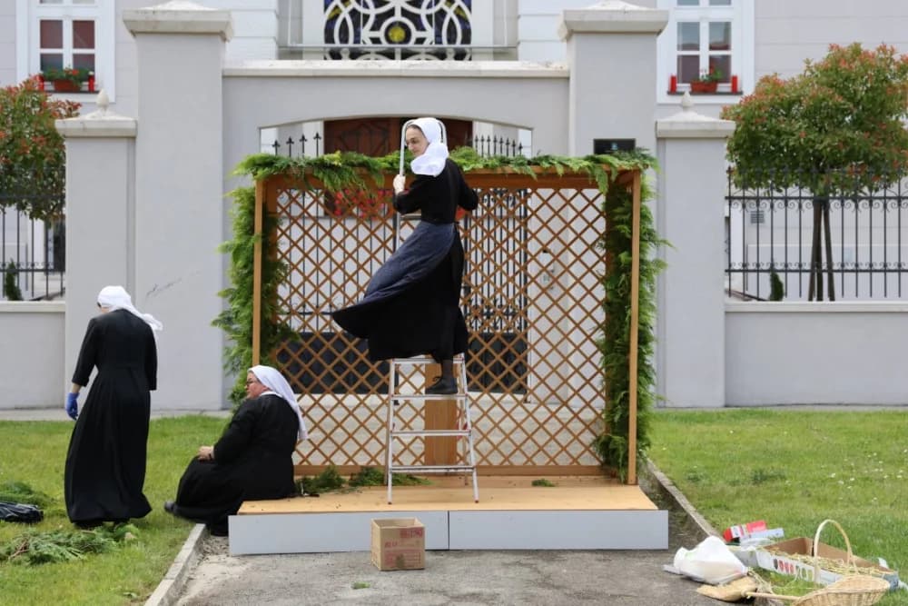 Vrijedne časne sestre milosrdnice pripremaju molitvenu postaju za današnju Tijelovsku procesiju