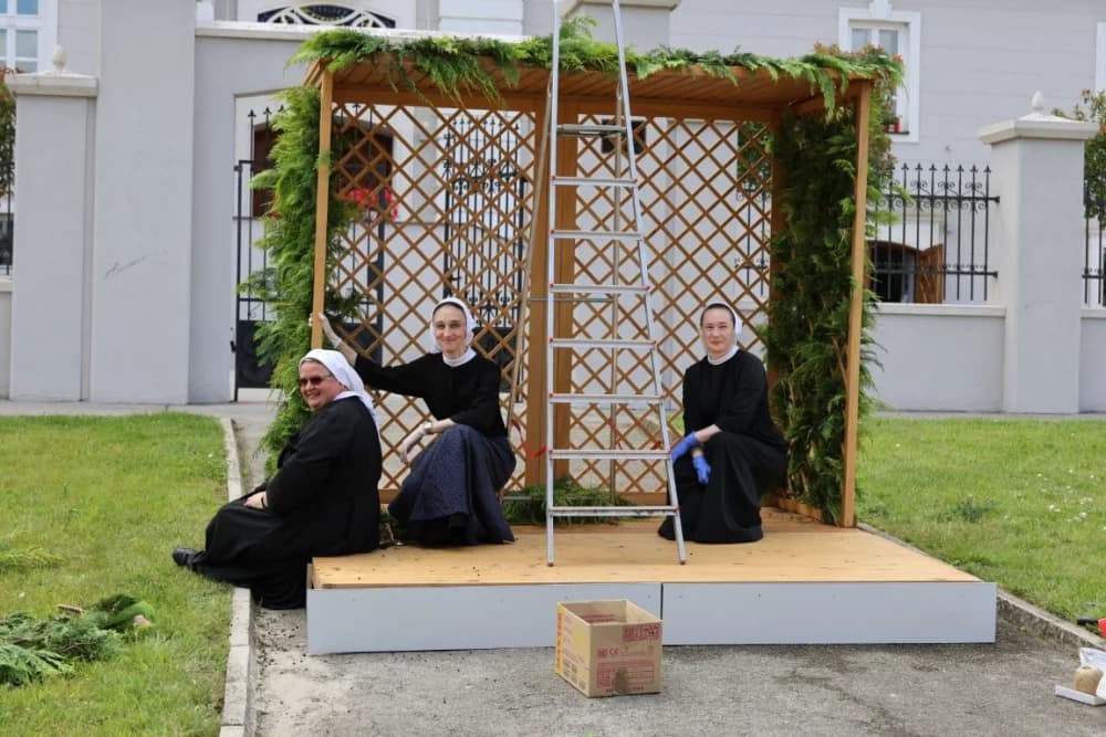 Vrijedne časne sestre milosrdnice pripremaju molitvenu postaju za današnju Tijelovsku procesiju